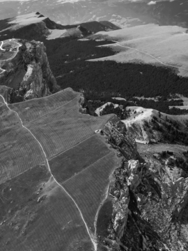 Aerial view of majestic mountains with green valleys and blue skies.