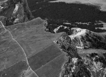 Aerial view of majestic mountains with green valleys and blue skies.