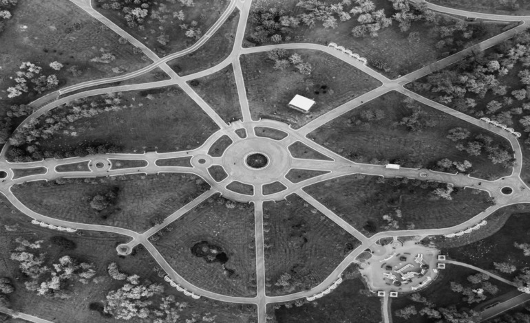 Aerial view of a lush green park with winding pathways and scattered trees.