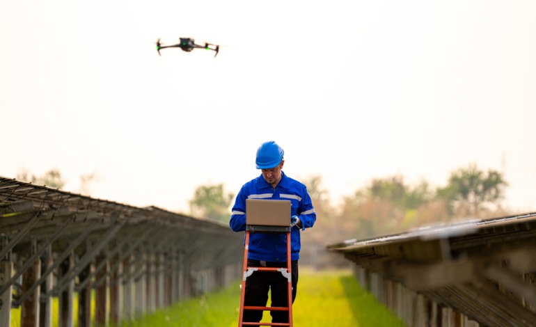 Drone operator conducting an inspection of solar panels, ensuring efficient energy use.